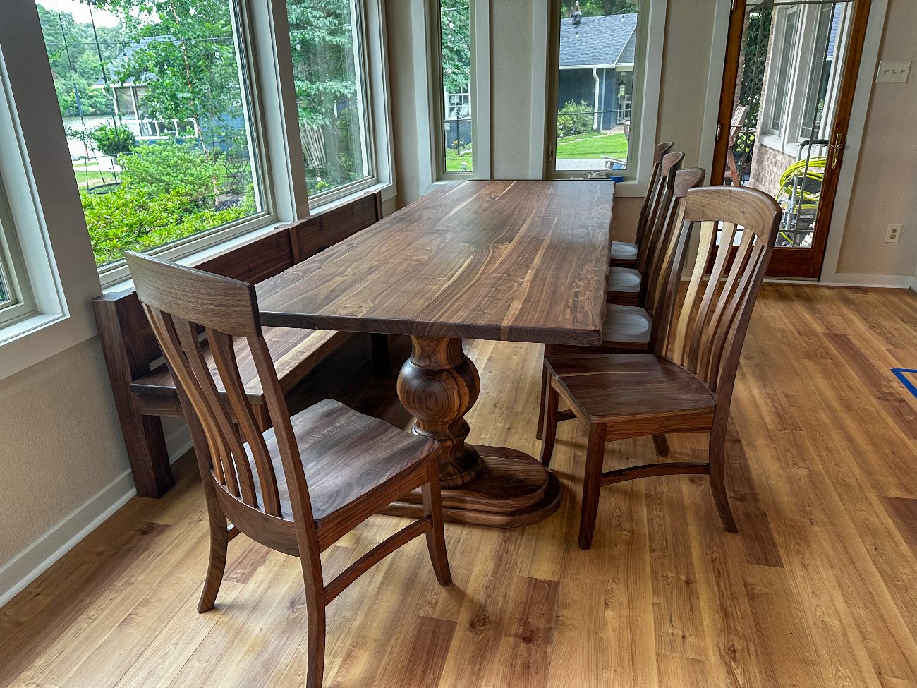 Walnut X-base dining table with matching bench in a modern kitchen