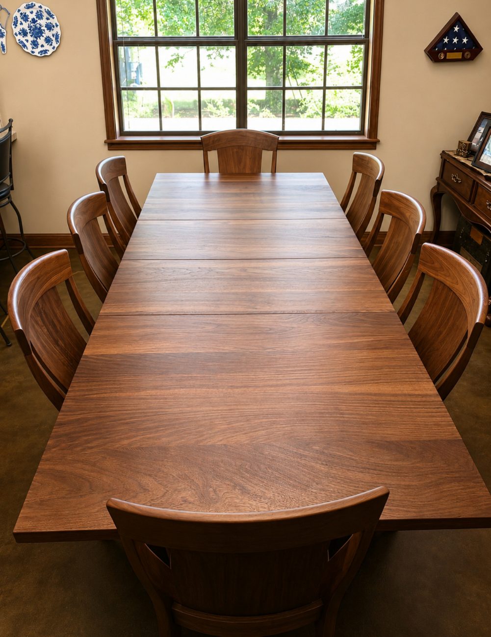 Live-edge walnut dining table and matching chairs by a wall of windows